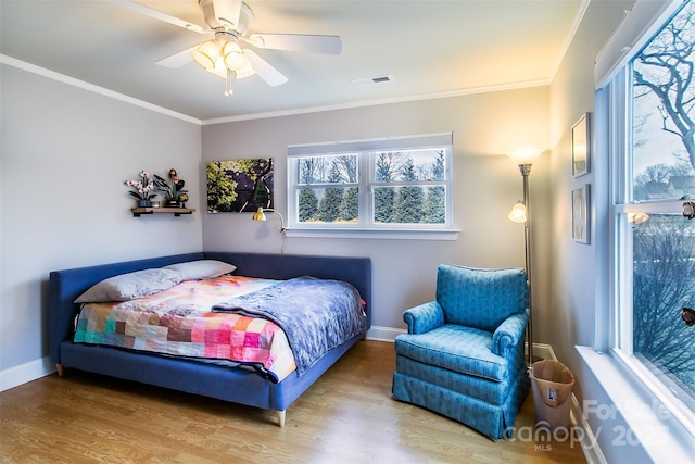 bedroom featuring crown molding, visible vents, and wood finished floors