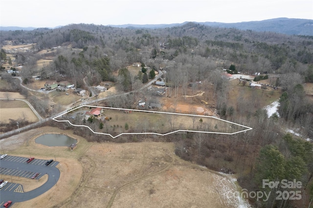 aerial view with a wooded view and a mountain view