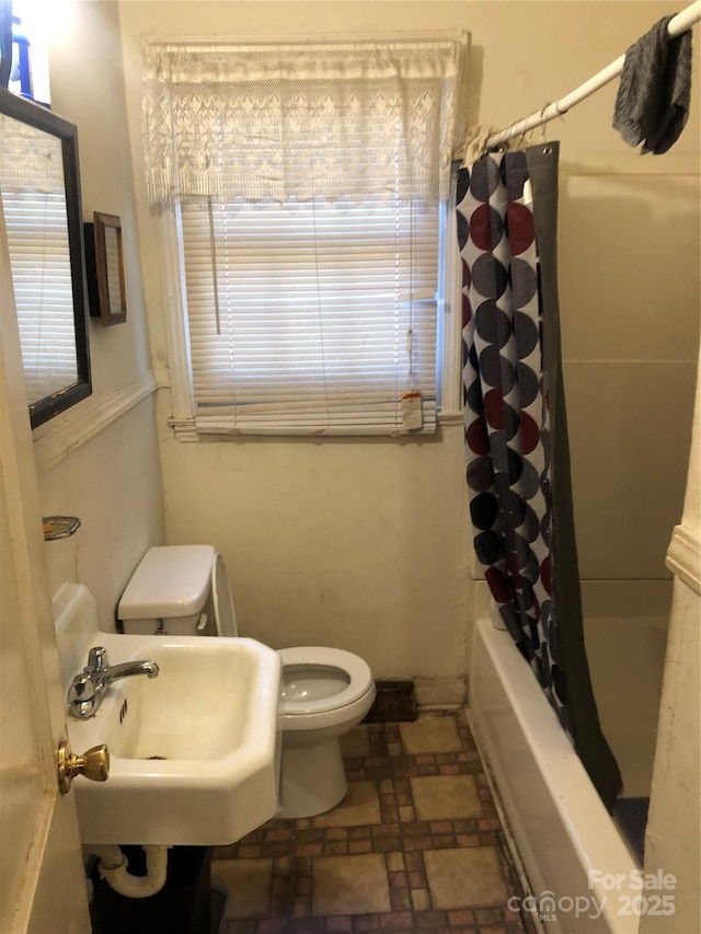 full bathroom with shower / bathtub combination with curtain, sink, and toilet