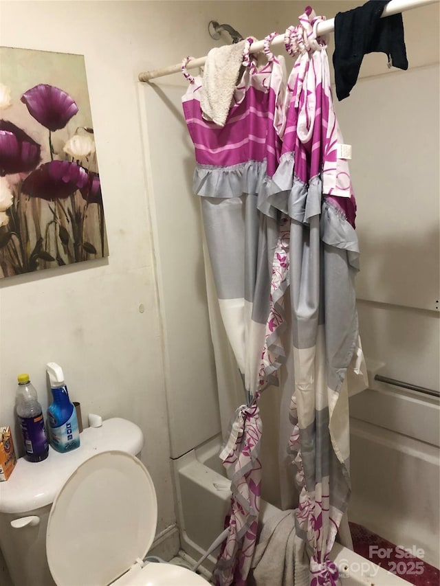 bathroom with toilet and shower / bath combo with shower curtain