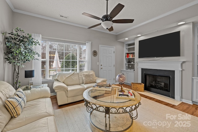 living room featuring ornamental molding, a textured ceiling, and light hardwood / wood-style flooring