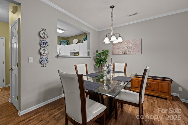 dining space featuring crown molding, dark hardwood / wood-style floors, an inviting chandelier, and a textured ceiling