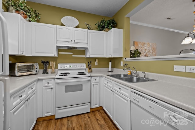 kitchen featuring hardwood / wood-style floors, decorative light fixtures, white cabinetry, sink, and white appliances