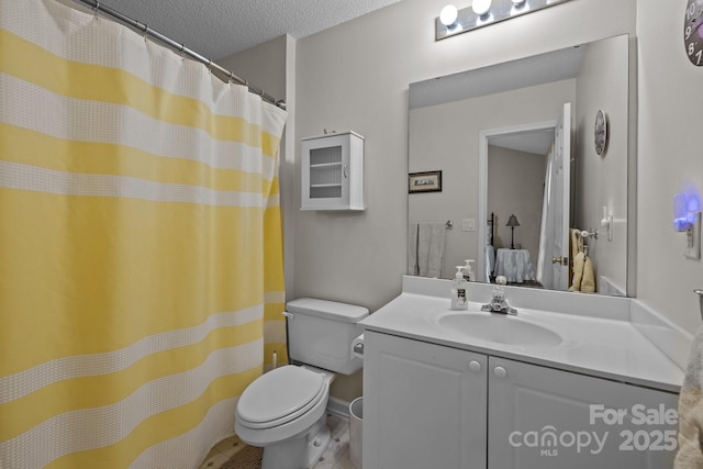 bathroom with vanity, a textured ceiling, and toilet