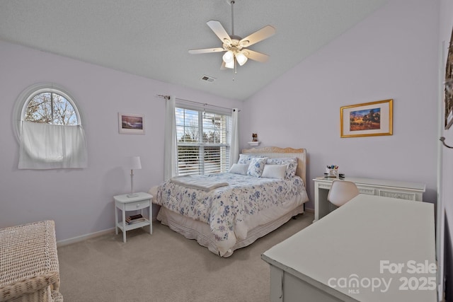 bedroom with a textured ceiling, vaulted ceiling, light colored carpet, and ceiling fan