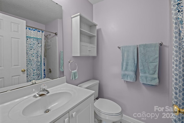 bathroom featuring a shower with curtain, vanity, a textured ceiling, and toilet