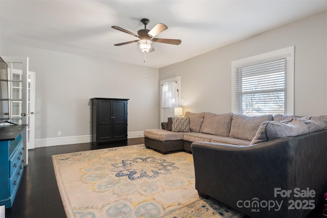 living room featuring ceiling fan and dark hardwood / wood-style floors