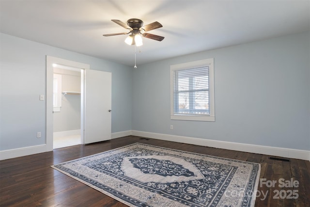 spare room with dark wood-type flooring and ceiling fan