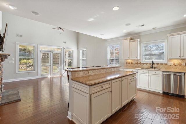 kitchen with dark hardwood / wood-style floors, dishwasher, sink, and backsplash