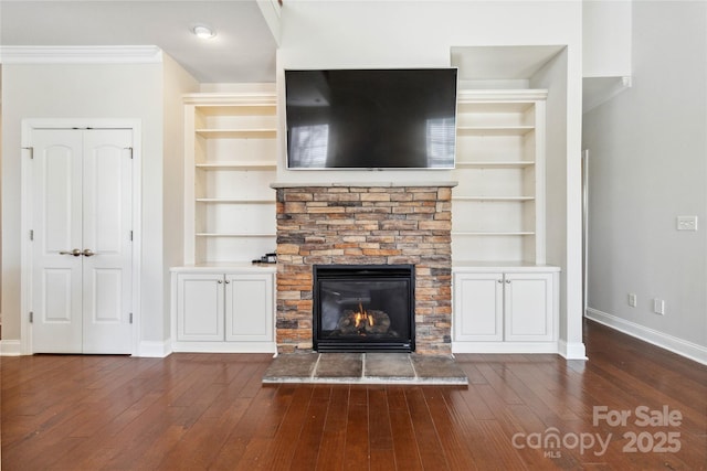 unfurnished living room featuring dark hardwood / wood-style floors, a fireplace, and built in features