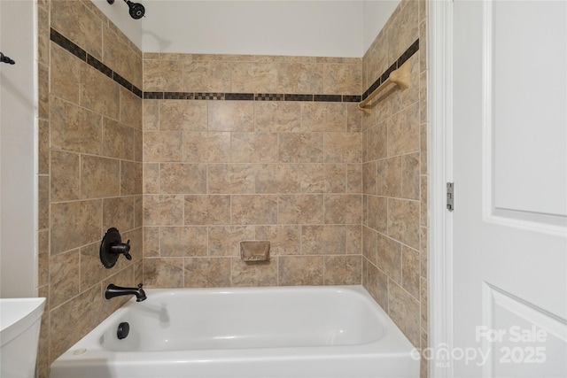 bathroom with toilet and tiled shower / bath combo