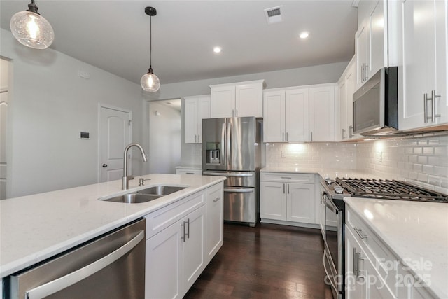 kitchen featuring stainless steel appliances, white cabinetry, hanging light fixtures, and sink