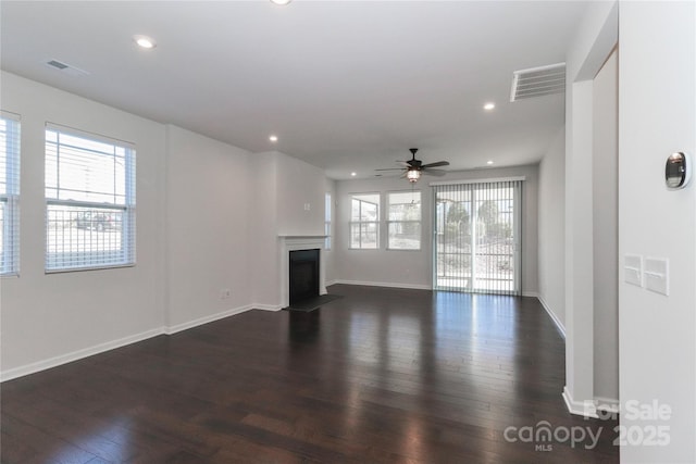 unfurnished living room featuring dark wood-type flooring and ceiling fan