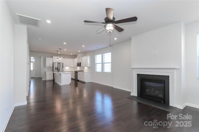 unfurnished living room with ceiling fan and dark hardwood / wood-style floors