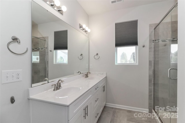 bathroom featuring vanity, plenty of natural light, and a shower with shower door