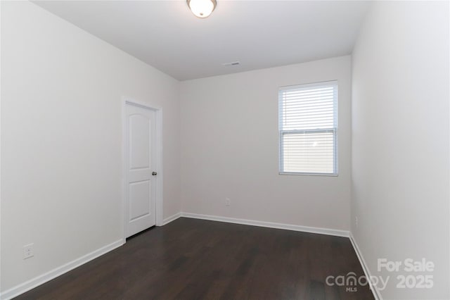 empty room with dark hardwood / wood-style flooring