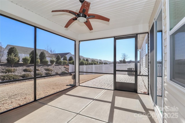 unfurnished sunroom featuring ceiling fan