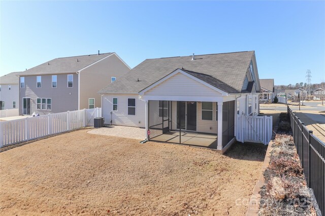 rear view of property with a sunroom, central AC unit, and a patio area