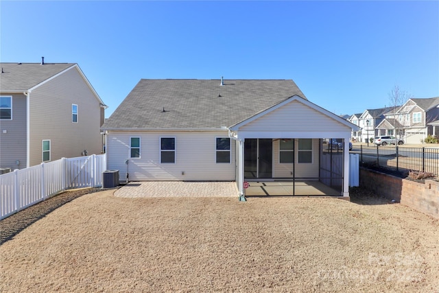 rear view of property featuring a sunroom, central AC unit, and a patio area