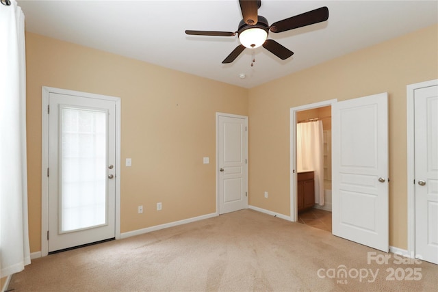 unfurnished bedroom featuring ceiling fan, ensuite bath, and light carpet