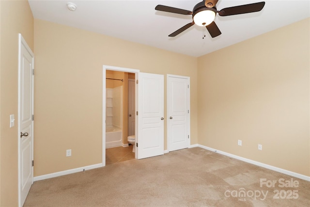 unfurnished bedroom with connected bathroom, light colored carpet, ceiling fan, and a closet