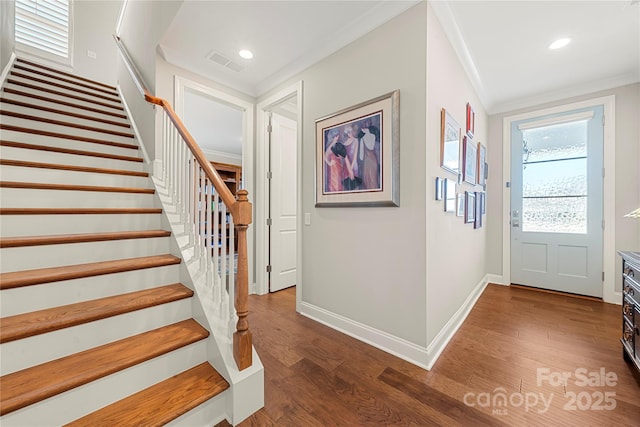 entrance foyer with ornamental molding and dark hardwood / wood-style flooring