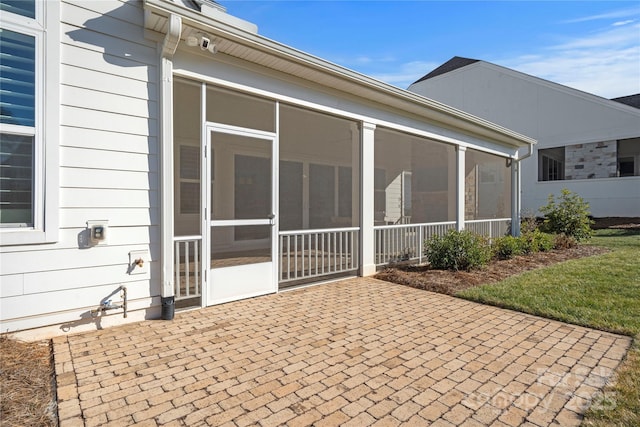 back of property featuring a yard, a patio area, and a sunroom