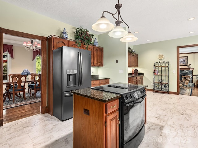 kitchen featuring hanging light fixtures, a textured ceiling, black / electric stove, stainless steel fridge, and a kitchen island