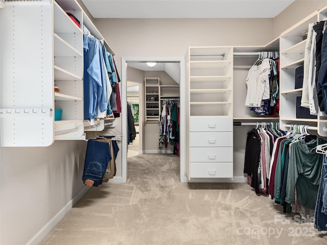 walk in closet featuring light carpet