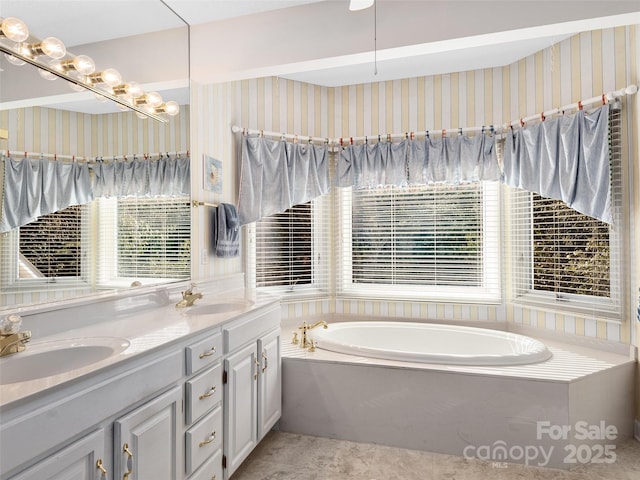 bathroom featuring vanity and a washtub