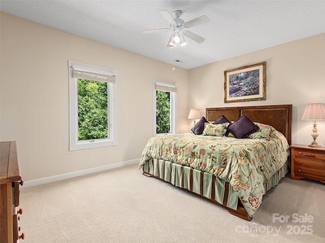 bedroom with a textured ceiling, carpet floors, and ceiling fan