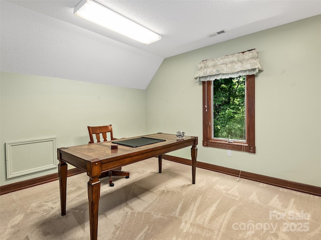 home office featuring vaulted ceiling, carpet floors, and a textured ceiling