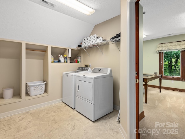 laundry room with a textured ceiling and washer and clothes dryer