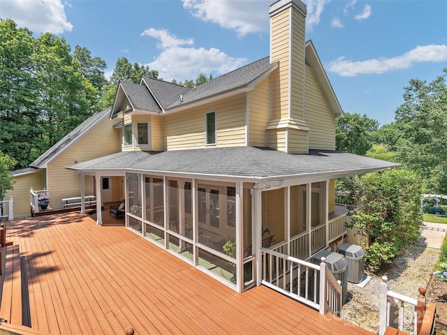 back of property with a wooden deck, a sunroom, and central air condition unit