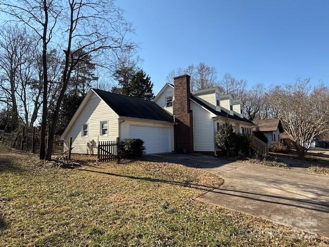 view of home's exterior with a garage and a yard