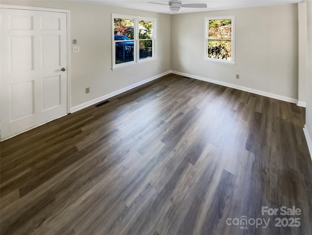 spare room with dark wood-type flooring, a wealth of natural light, and ceiling fan