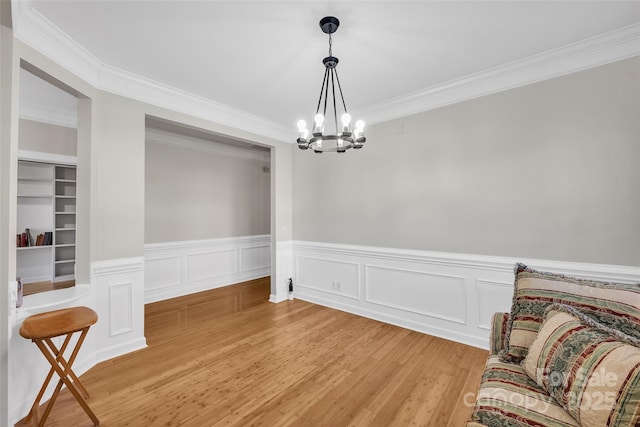 dining area featuring an inviting chandelier, hardwood / wood-style floors, and crown molding