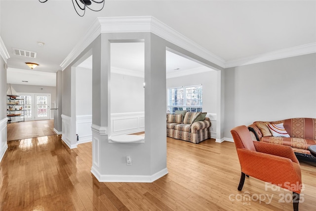 living room with crown molding and light hardwood / wood-style flooring