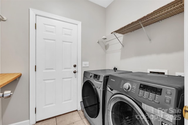 laundry area featuring washing machine and dryer and light tile patterned flooring