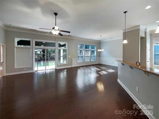 unfurnished living room featuring crown molding, dark hardwood / wood-style flooring, and ceiling fan with notable chandelier