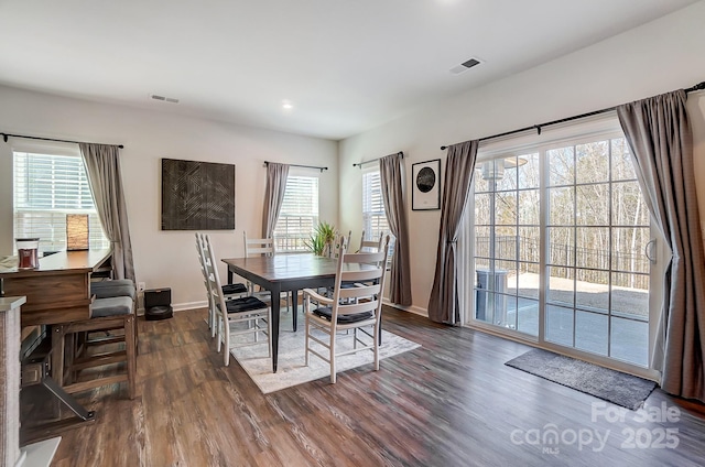 dining area with plenty of natural light and dark hardwood / wood-style floors