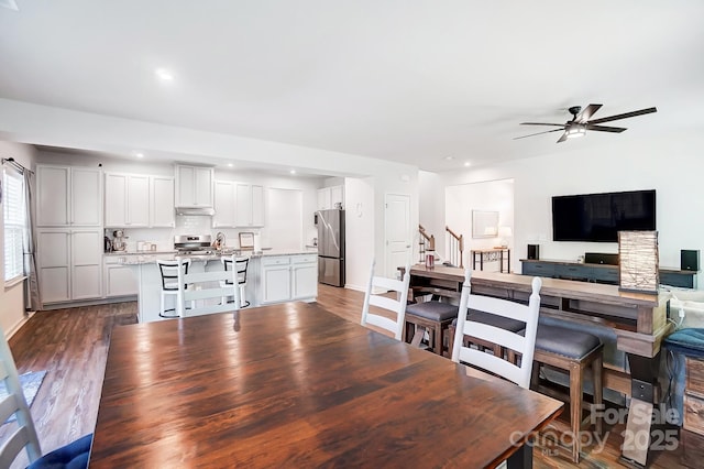 dining area with dark wood-type flooring and ceiling fan