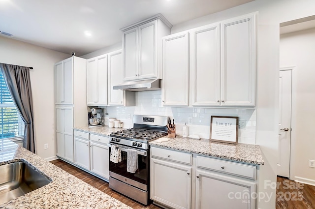 kitchen featuring tasteful backsplash, white cabinetry, light stone countertops, and stainless steel gas stove