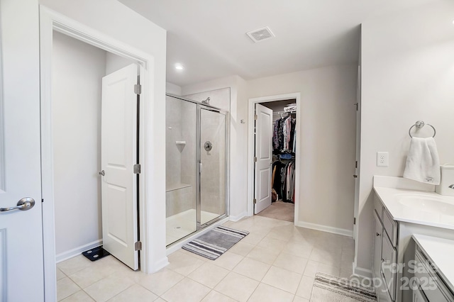 bathroom with tile patterned floors, vanity, and a shower with shower door