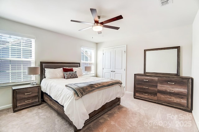 carpeted bedroom with ceiling fan and a closet