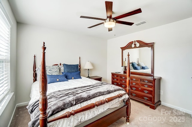 carpeted bedroom with multiple windows and ceiling fan