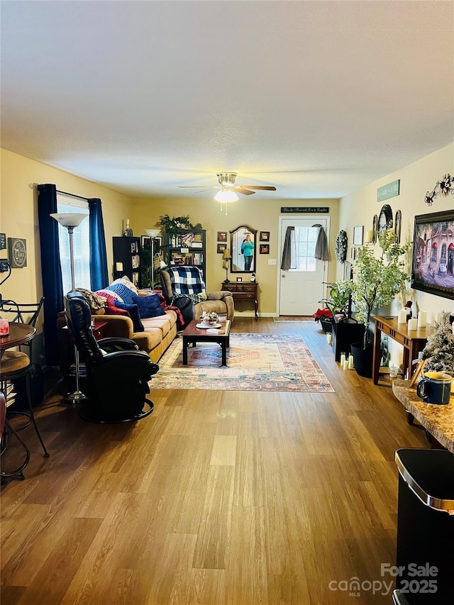 living room with hardwood / wood-style floors, a wealth of natural light, and ceiling fan