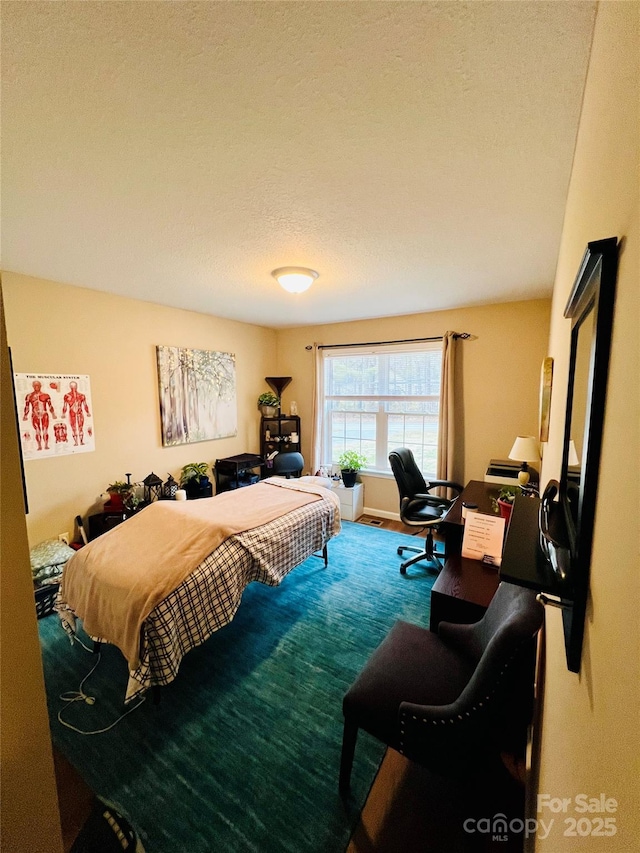 carpeted bedroom featuring a textured ceiling