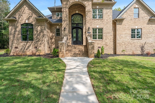 view of front of home featuring a front lawn and french doors