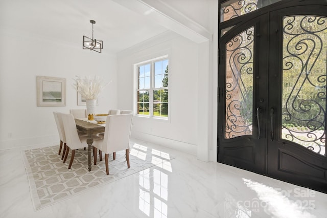 entrance foyer with an inviting chandelier, ornamental molding, and french doors